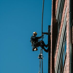 A man on a high wire working on a building